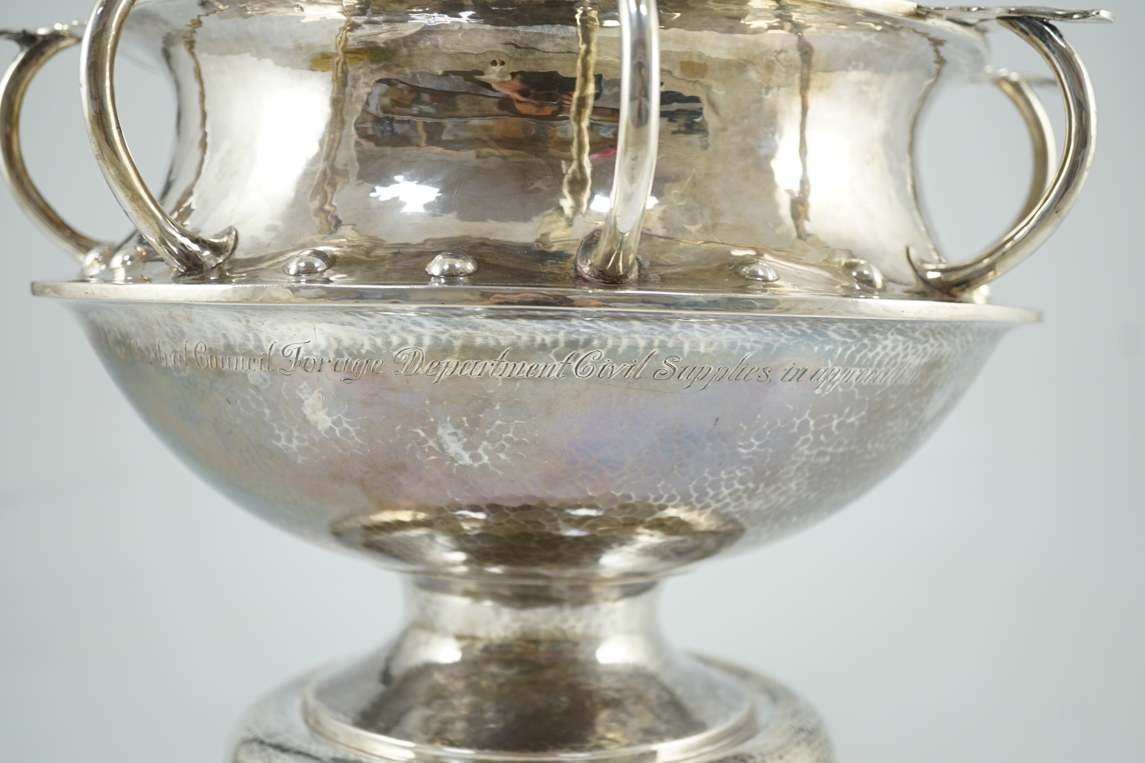 A George V Arts & Crafts planished silver octuple handled pedestal punch bowl, by Albert Edward Jones